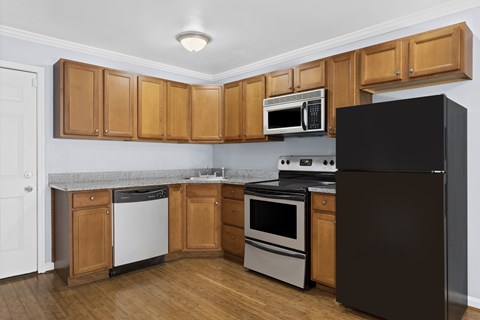 A kitchen with wooden cabinets and black appliances.